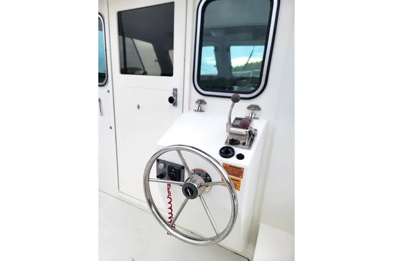 Slide: The Image of Steering wheel and controls of a 2017 Parker 2120 Sport Cabin boat. - 8