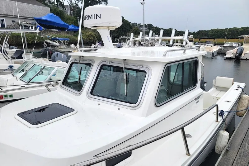 Slide: The Image of 2017 Parker 2120 Sport Cabin boat docked, featuring Garmin radar and sleek design. - 8