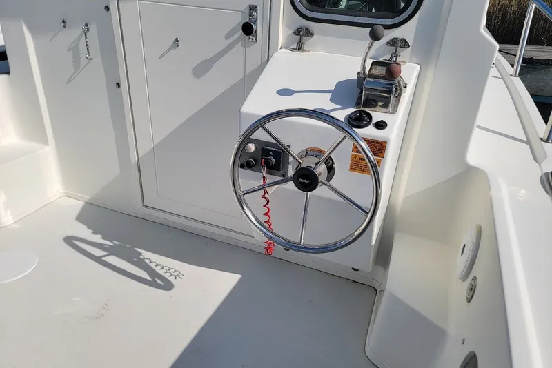 Slide: The Image of Steering console of a 2017 Parker 2120 Sport Cabin boat, featuring a chrome wheel. - 5