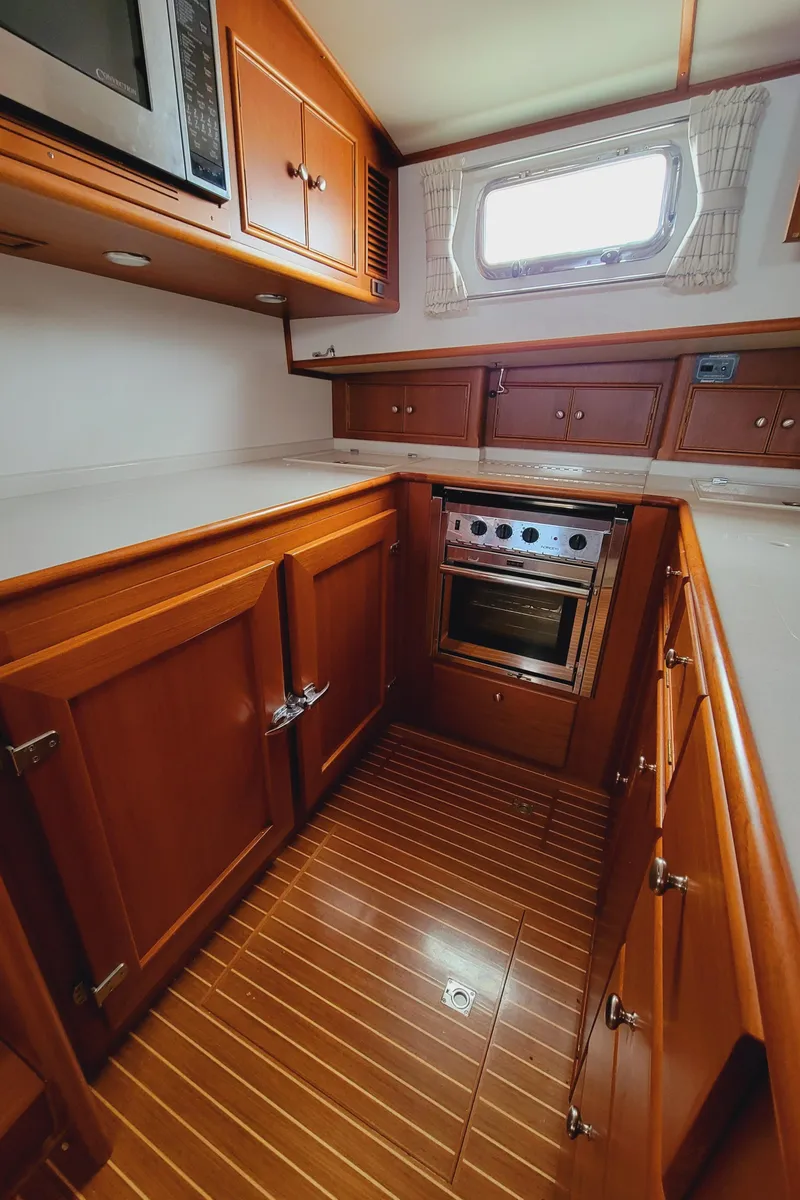 Slide: The Image of 2004 Grand Banks 49 Eastbay HX kitchen with wooden cabinets. - 18