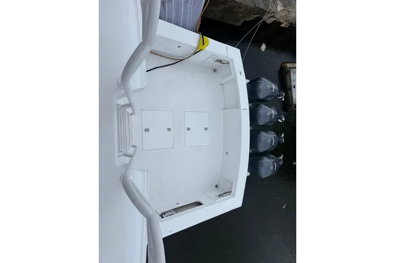Slide: The Image of 1984 Ocean 55 Super Sport boat deck with four outboard motors, docked. - 14