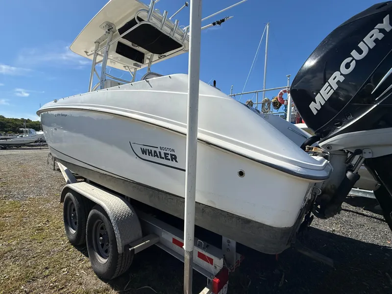 Slide: The Image of A 2006 Boston Whaler 270 Outrage on a trailer, featuring a Mercury outboard motor. - 49
