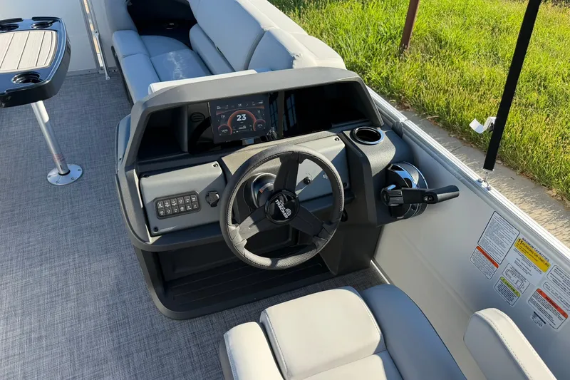 Slide: The Image of 2027 Sun Tracker Party Barge 22 RF DLX helm with modern controls and seating. - 19
