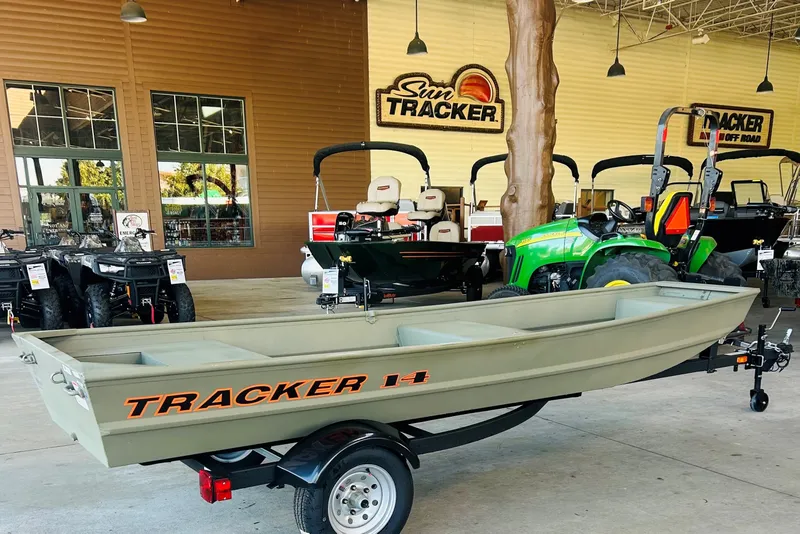The Image of 2027 Tracker Grizzly 14 Jon boat displayed in showroom with tractors and ATVs. - 0