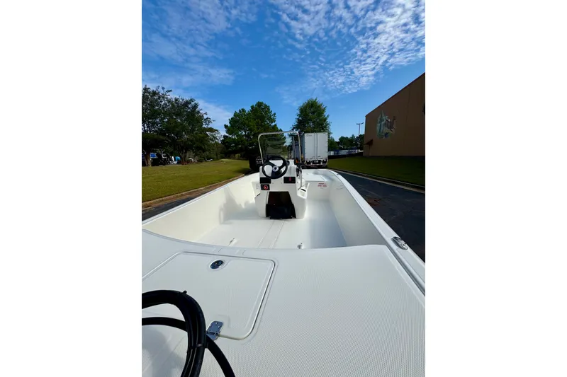Slide: The Image of 2027 Mako Pro Skiff 17 CC boat on a sunny day, showcasing interior and steering console. - 3
