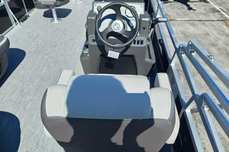 Slide: The Image of 2027 Sun Tracker Bass Buggy 18 DLX boat interior with steering wheel and seating. - 18