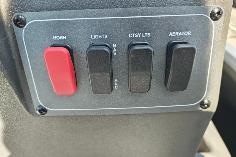 Slide: The Image of Control panel of 2027 Sun Tracker Bass Buggy 18 DLX with switches for horn, lights, and aerator. - 21