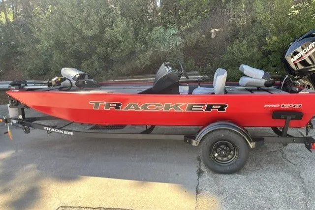 The Image of 2027 Tracker Pro 170 boat in red on a trailer, parked outdoors. - 0