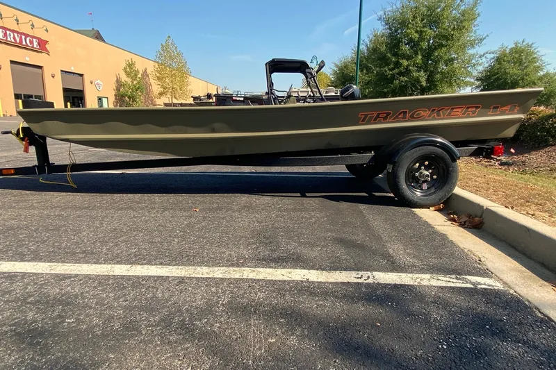 The Image of 2027 Tracker Grizzly 14 Jon boat on trailer in parking lot. - 0