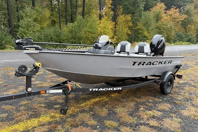 The Image of 2027 Tracker Super Guide V-16 SC boat on trailer, surrounded by autumn trees. - 0