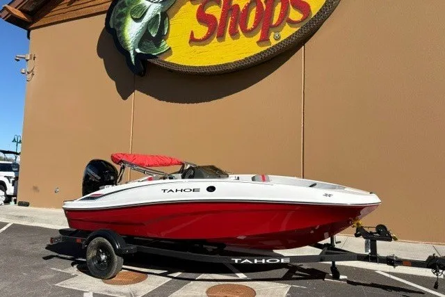 The Image of 2027 Tahoe T16 boat with red and white design on trailer outside store. - 0