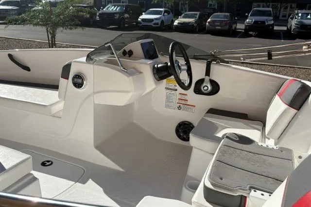 Slide: The Image of 2027 Tahoe T16 boat interior with steering wheel and seating, parked outdoors. - 5