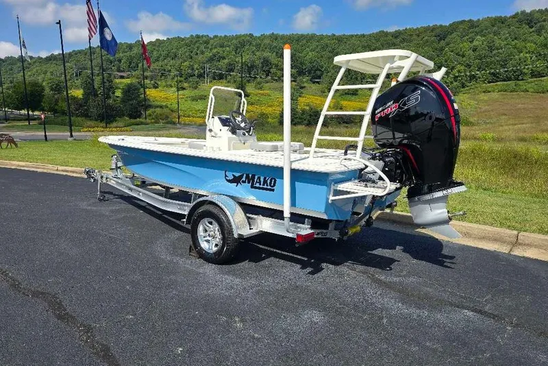 Slide: The Image of 2026 Mako 18 Pro Skiff boat on trailer, parked outdoors with scenic background. - 13