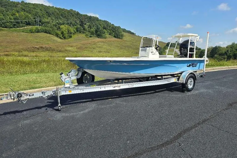 Slide: The Image of 2026 Mako 18 Pro Skiff boat on trailer, parked on a scenic road. - 4