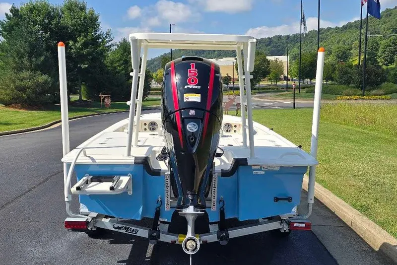 Slide: The Image of 2026 Mako 18 Pro Skiff with powerful outboard motor, parked on a sunny day. - 12
