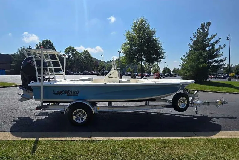Slide: The Image of 2026 Mako 18 Pro Skiff boat on trailer, parked outdoors under clear blue sky. - 10