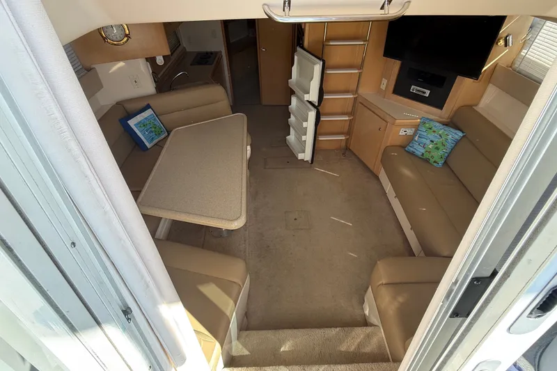 Slide: The Image of Interior of 1998 Carver 350 Mariner yacht with seating, table, and entertainment area. - 13