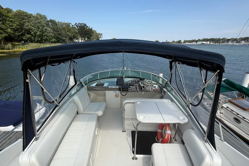 Slide: The Image of 1998 Carver 350 Mariner boat interior with seating, table, and helm under canopy. - 11