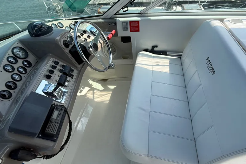 Slide: The Image of 1998 Carver 350 Mariner helm with steering wheel, gauges, and white seating. - 10