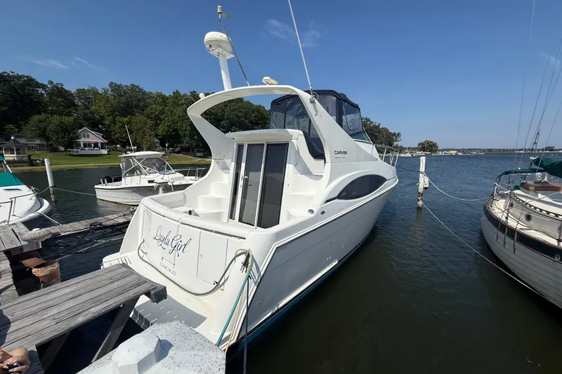 Slide: The Image of 1998 Carver 350 Mariner yacht docked at a marina on a sunny day. - 3