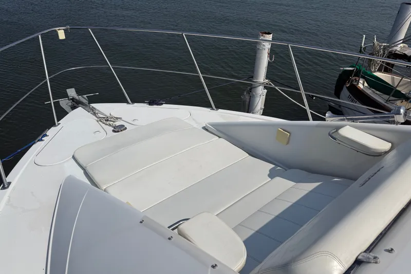 Slide: The Image of 1998 Carver 350 Mariner boat deck with white seating and railing, docked by water. - 9
