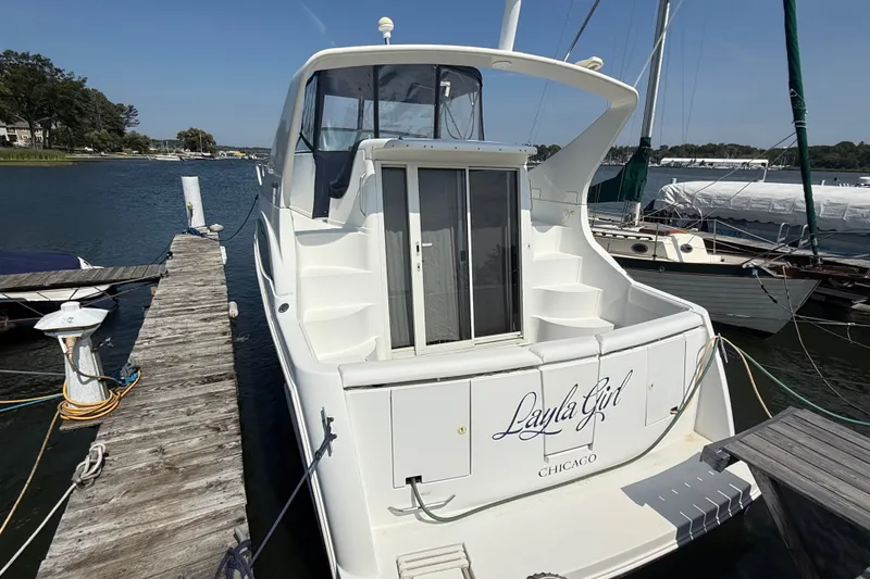 Slide: The Image of 1998 Carver 350 Mariner docked, rear view with "Layla Girl" name, sunny day. - 6