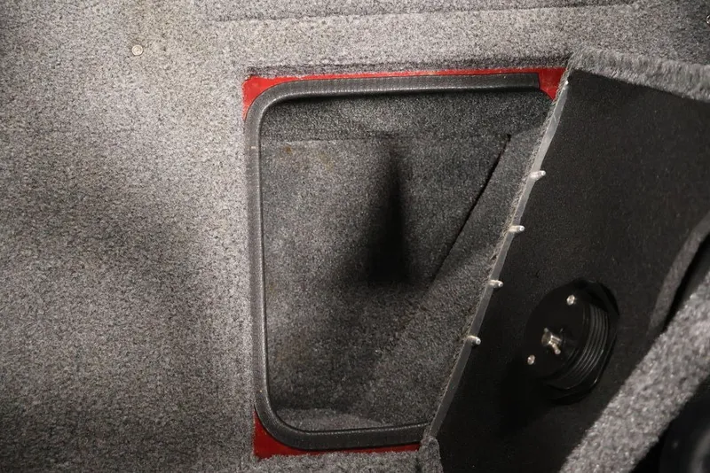 Slide: The Image of Open storage compartment in 2022 Tracker Targa V-19 WT boat, featuring carpeted interior. - 24