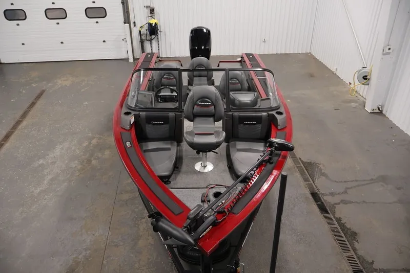 Slide: The Image of 2022 Tracker Targa V-19 WT boat in a garage, featuring red and black seating. - 57