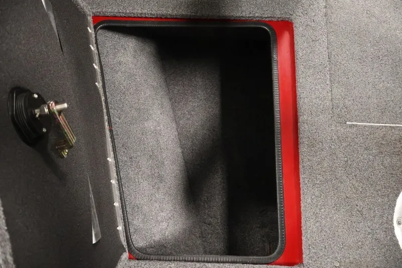 Slide: The Image of 2022 Tracker Targa V-19 WT storage compartment with red trim and carpeted interior. - 17