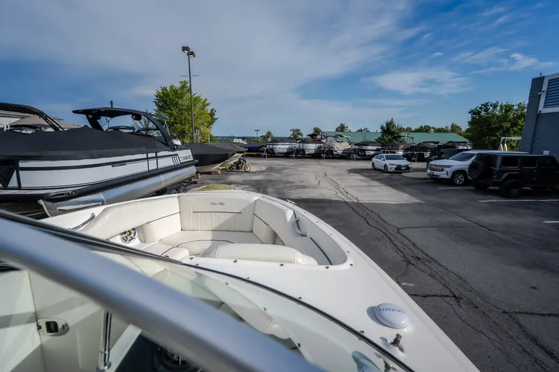 Slide: The Image of 2006 Sea Ray 270 SLX boat in a parking lot with other vehicles and boats. - 28