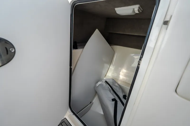 Slide: The Image of Storage compartment inside a 2006 Sea Ray 270 SLX boat, featuring a white interior. - 25