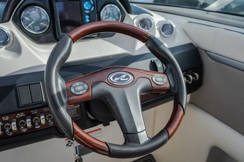Slide: The Image of Steering wheel of a 2006 Sea Ray 270 SLX boat with dashboard controls. - 21