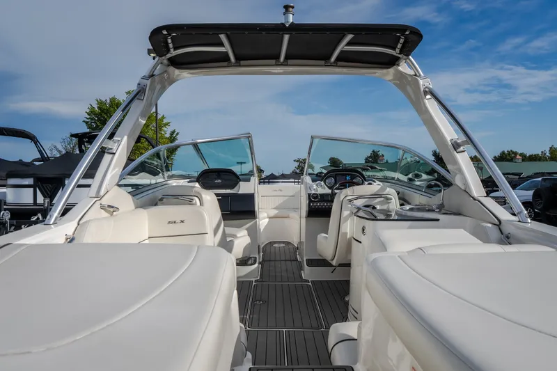 Slide: The Image of 2006 Sea Ray 270 SLX boat interior with white seating and sleek dashboard under blue sky. - 14