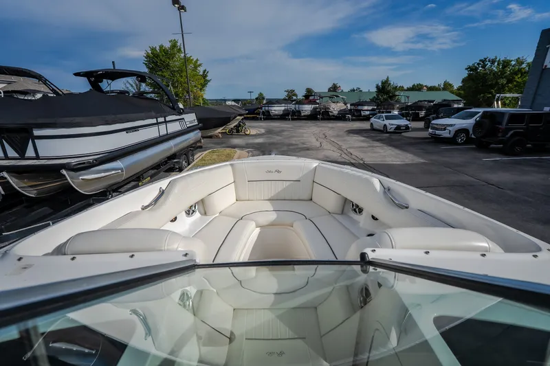 Slide: The Image of 2006 Sea Ray 270 SLX boat interior with white seating, parked in a marina. - 27