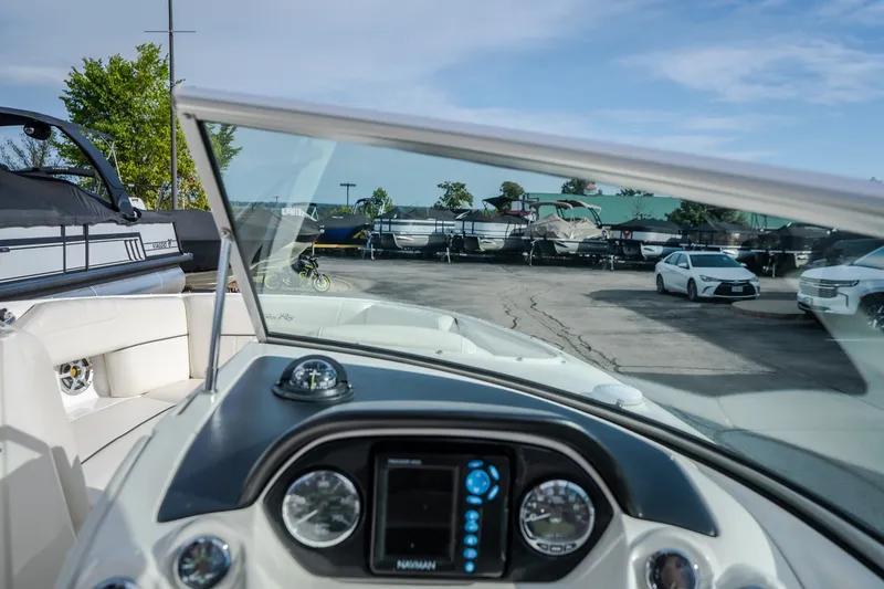 Slide: The Image of 2006 Sea Ray 270 SLX boat dashboard view in a marina with parked boats and cars. - 20