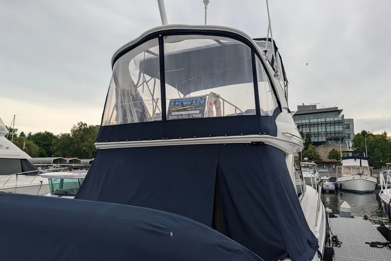 Slide: The Image of 2001 Bayliner 3788 Command Bridge Motoryacht docked at marina, covered in navy canvas. - 64