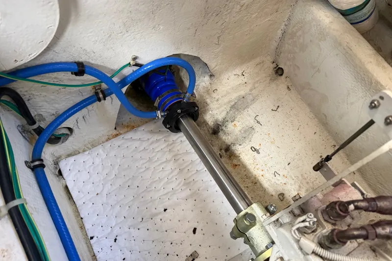 Slide: The Image of Engine compartment of a 2001 Bayliner 3788 Command Bridge Motoryacht, showing blue hoses and metal shaft. - 57