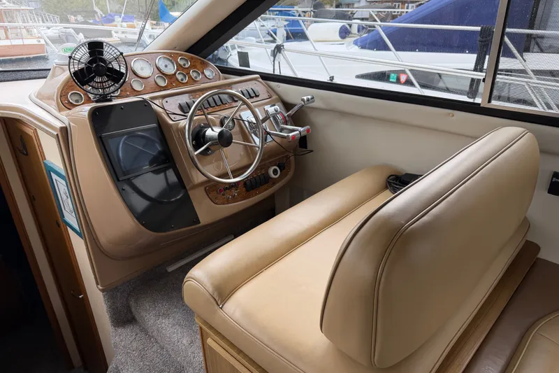 Slide: The Image of 2001 Bayliner 3788 Command Bridge Motoryacht helm with beige seating and control panel. - 18