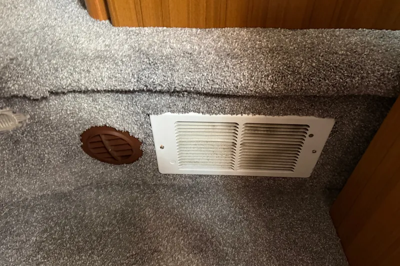 Slide: The Image of Carpeted interior of 2001 Bayliner 3788 yacht with air vent and wooden paneling. - 25