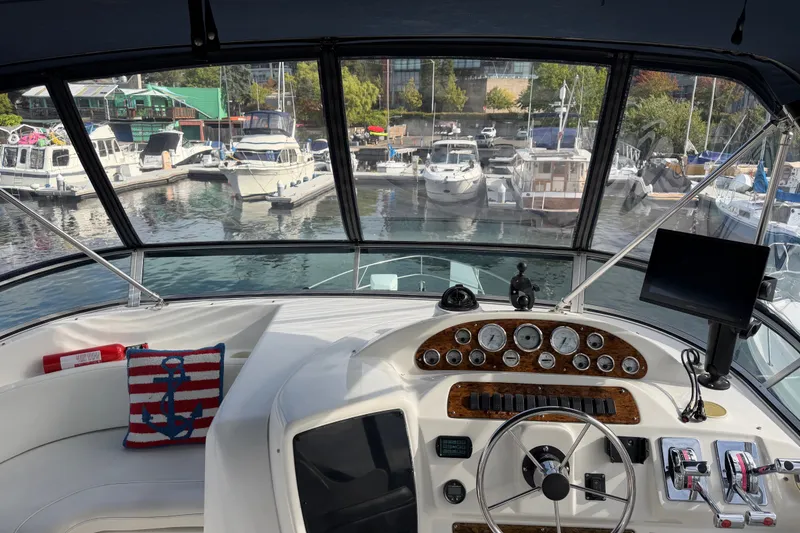 Slide: The Image of 2001 Bayliner 3788 Command Bridge Motoryacht helm with marina view, featuring nautical decor. - 44