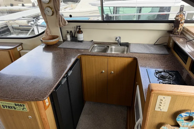 Slide: The Image of 2001 Bayliner 3788 Command Bridge Motoryacht kitchen with sink, stove, and countertop. - 13