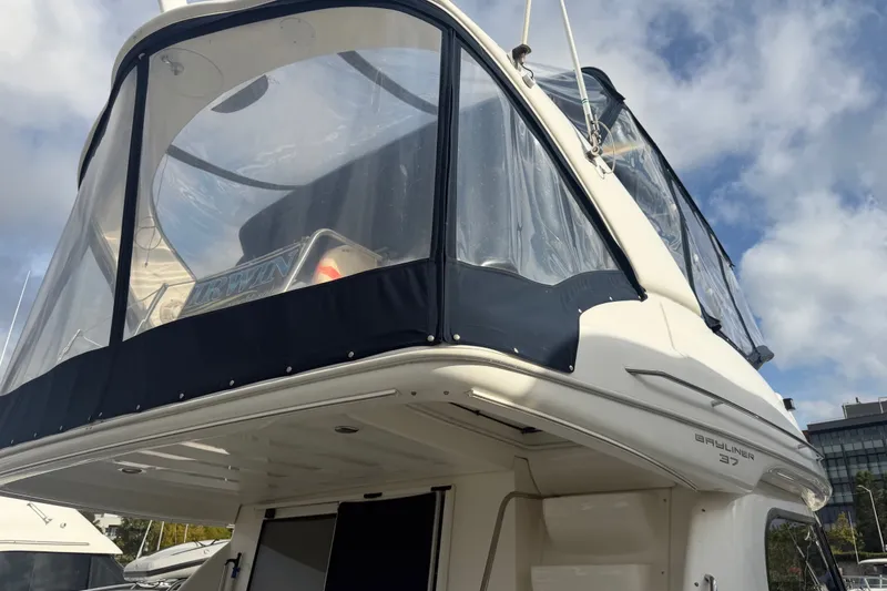 Slide: The Image of 2001 Bayliner 3788 Command Bridge Motoryacht with enclosed upper deck, under a cloudy sky. - 72