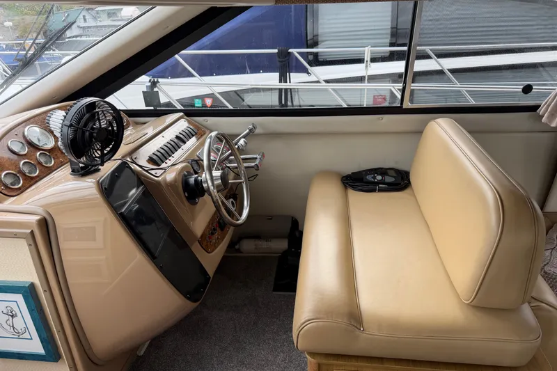 Slide: The Image of 2001 Bayliner 3788 Command Bridge Motoryacht helm with tan seating and steering wheel. - 19