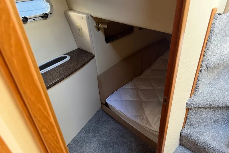 Slide: The Image of 2001 Bayliner 3788 Command Bridge Motoryacht cabin with bed, stairs, and window. - 37