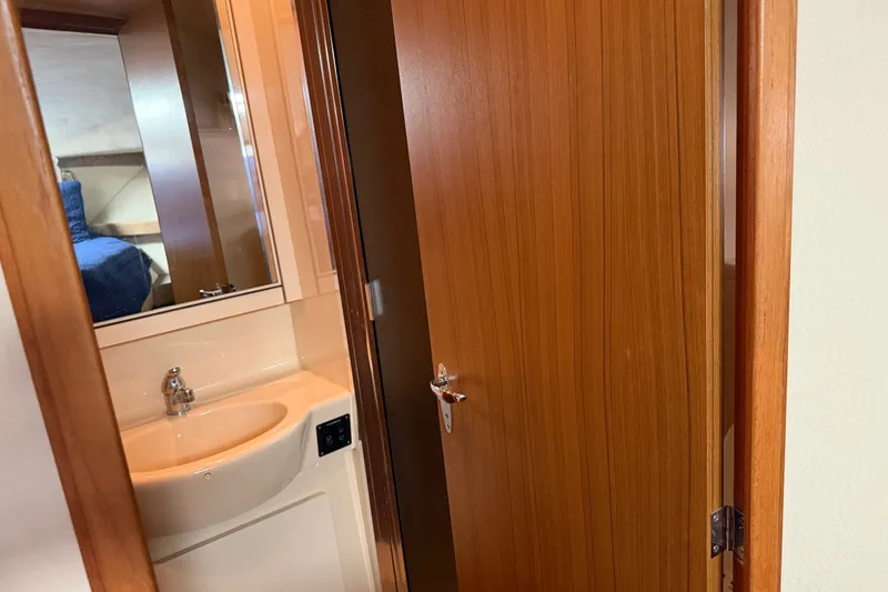 Slide: The Image of Interior of 2001 Bayliner 3788 yacht showing bathroom sink and wooden door. - 30