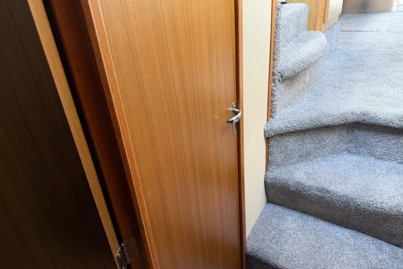 Slide: The Image of Interior view of 2001 Bayliner 3788 Command Bridge Motoryacht with carpeted stairs and wooden door. - 36