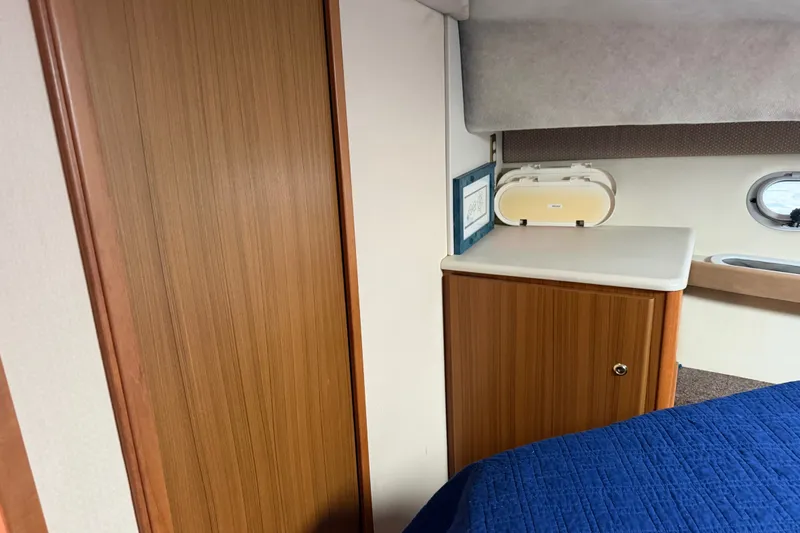 Slide: The Image of Interior of 2001 Bayliner 3788 Command Bridge Motoryacht with wood cabinetry and blue bedding. - 28