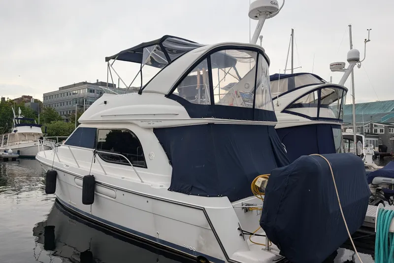 Slide: The Image of 2001 Bayliner 3788 Command Bridge Motoryacht docked at marina, covered in blue canvas. - 3