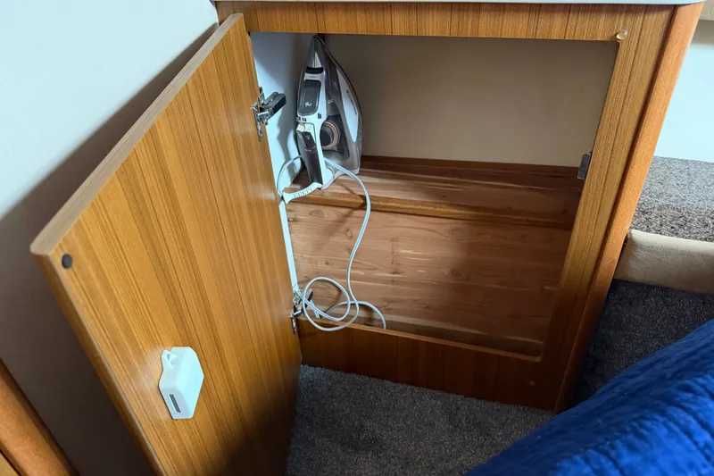 Slide: The Image of Open wooden cabinet with an iron inside on a Bayliner 3788 Command Bridge Motoryacht, 2001. - 29