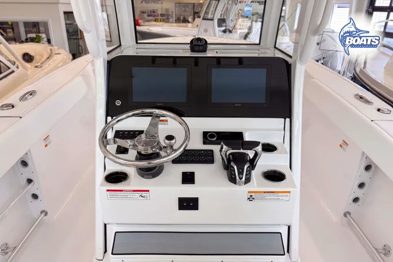 Slide: The Image of 2027 Sportsman Heritage 261 Center Console boat dashboard with dual screens and steering wheel. - 7